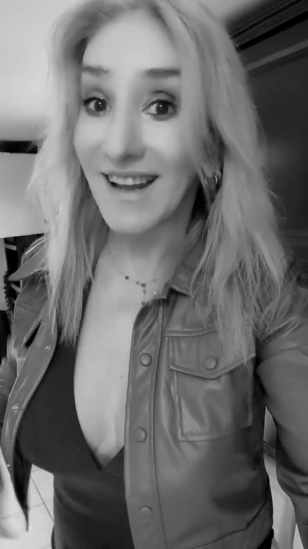 Black-and-white photograph of Stevie mid-laugh in an open shirt
